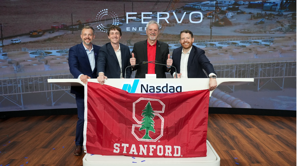Four men in suits pose behind a Nasdaq podium, holding a red Stanford banner with the Stanford tree logo on a stage backdrop that includes 'FERV0' energy branding.
